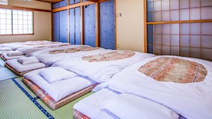A traditional Japanese room with tatami mats, shoji screens, and futon beds. - Tabist Hotel Fuji (Daisen)