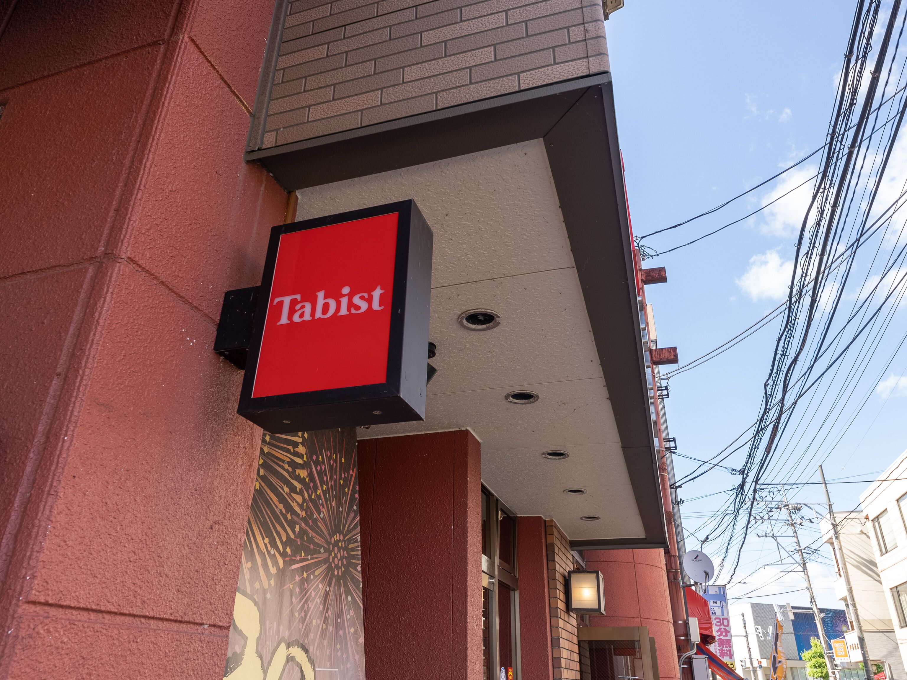 A red sign with the word "Tabist" on a building facade.