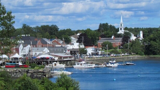A coastal town with a prominent church steeple, a dock with boats, and buildings along the waterfront. - Quiet Riverfront getaway to enjoy Midcoast Maine! (Damariscotta)