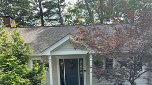 A house with a front porch, a small garden, and a driveway. - Quiet Riverfront getaway to enjoy Midcoast Maine! (Damariscotta)