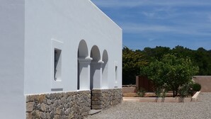 Un edificio bianco con tre finestre ad arco e una base in pietra.