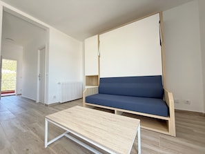 A modern living room with a sofa, a coffee table, and a radiator.