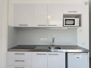 A modern kitchen with white cabinets, a stainless steel sink, a microwave, and a dishwasher. - Agi Rescator 219 Apartamento for rent in Roses Girona. (Rosas / Roses)