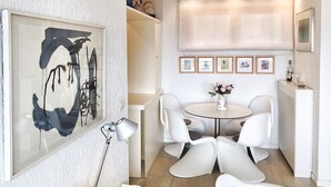 A compact dining area with a round table and four chairs, a framed abstract painting, and a radiator. - Cordelia 6 with lake view, balcony and pool (Luino)