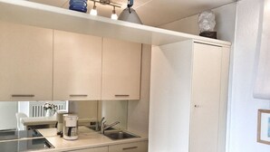 A compact kitchen with a stove, sink, and a coffee maker. - Cordelia 6 with lake view, balcony and pool (Luino)