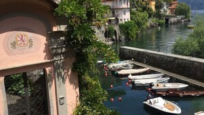 A coastal town with boats docked at a marina, surrounded by lush greenery and traditional buildings. - Casa al Vecchio Porto overlooking the ancient port (Cannero Riviera)