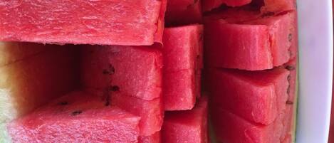 A white plate with neatly cut watermelon pieces.