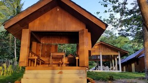 A wooden cabin with a porch and outdoor seating area. - Aundanao Oasis Beach (Samal)