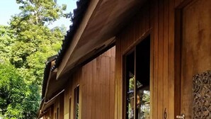 A wooden building with a covered porch and a small garden area with steps leading up to the entrance. - Aundanao Oasis Beach (Samal)