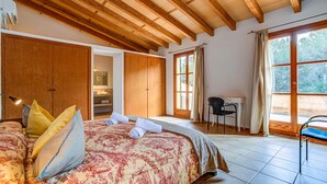 Une chambre à coucher avec un grand lit, une armoire en bois, un bureau et une chaise.