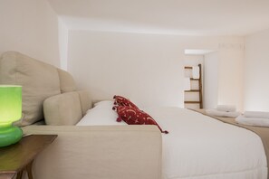 Una camera d'albergo ordinata con un letto, una lampada verde e un comodino in legno.