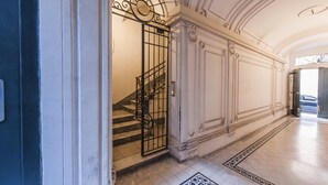 A grand hallway with a staircase, ornate columns, and a patterned floor. - Babuino Superior - Spanish steps (Roma)
