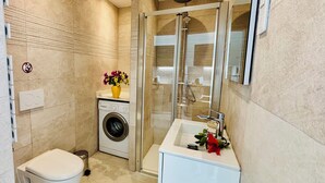 A modern bathroom with a glass shower enclosure, a built-in washing machine, and a sink with a mirror. - Sunset paradise in Villefranche (Villefranche-sur-Mer)