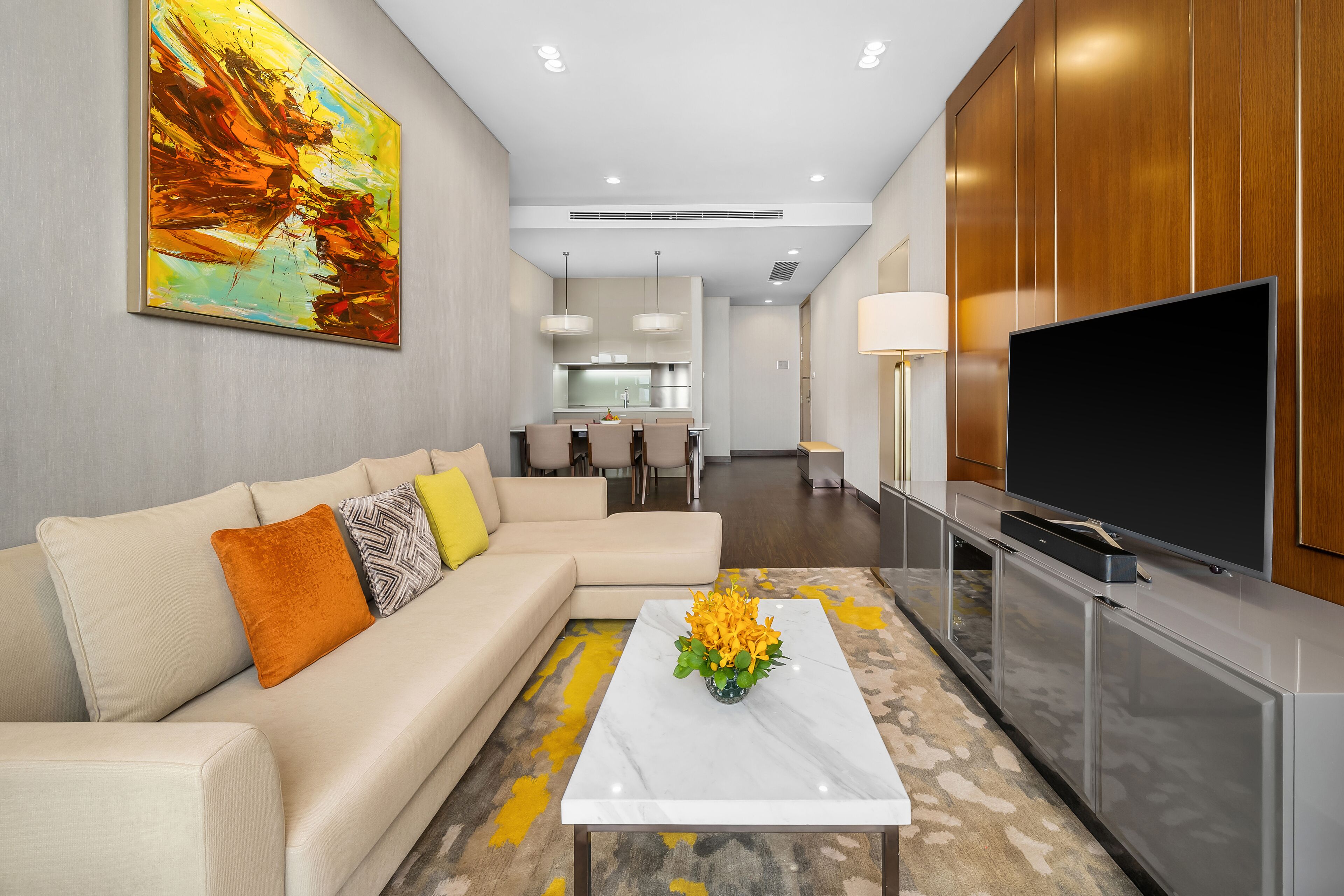 A modern living room with a sofa, coffee table, and a flat-screen TV.