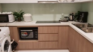 Une cuisine moderne équipée d’un four à micro-ondes encastré, d’une machine à café et d’un petit four.