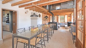 A spacious dining area with a long table, chairs, and a central chandelier. - Can Cortana - Charming country house with pool in Inca, Mallorca (Inca)
