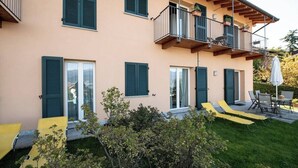 A two-story building with balconies, green shutters, and outdoor seating. - Africa apartment over Stresa with lake view (Stresa)