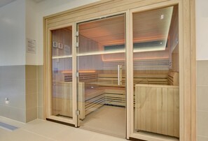 Una sauna con panche di legno e porte in vetro, pavimento piastrellato e orologio a parete.