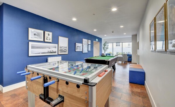 A room with a foosball table, a pool table, and framed pictures on the wall. - 3 Bed in Woolacombe (oc-5byron) (Woolacombe)