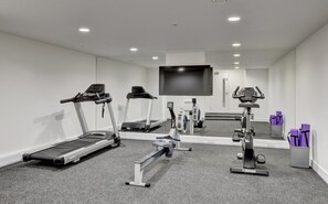 Una palestra con tapis roulant, ellittiche e cyclette.
