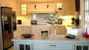A kitchen with white cabinetry, a central island with a vase, and a stainless steel refrigerator. - Luxurious Private Villa with Private Pool and Sea Views- 6 min drive from beach (gouves)