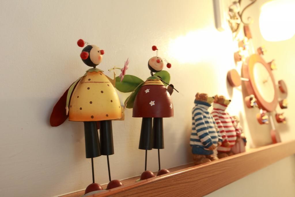 A shelf with various figurines, including a couple and a bear, against a plain wall.
