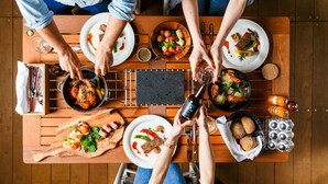 A dining table with multiple plates of food, a pan with roasted chicken, and a bottle of sauce. - Fujino Kirameki (Gotemba)