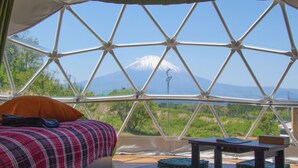 A room with a bed, a table, and a view of a mountain. - Fujino Kirameki (Gotemba)