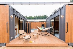 A modern container home with a deck, outdoor seating, and a hammock. - Fujino Kirameki (Gotemba)