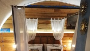 Una cama con dosel y cortinas, paneles de madera en las paredes y un cartel con un número a la izquierda.