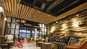 A modern interior with a wooden ceiling, a striped sofa, and a pink sculpture. - Pinestone Inn (Ji'an)