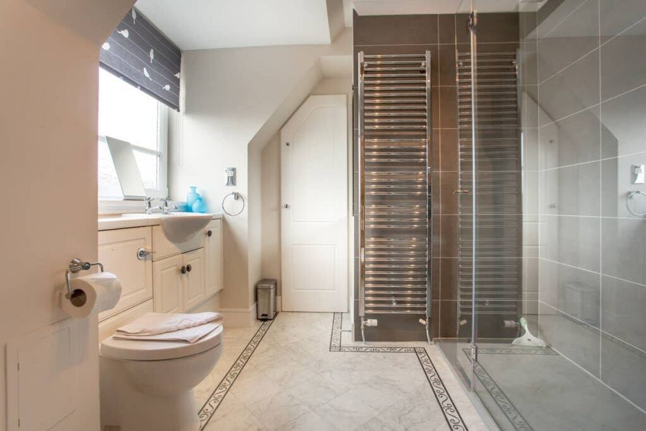 A modern bathroom with a toilet, sink, and shower area.