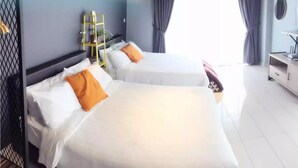 Two beds with white linens and orange pillows, a small table with a lamp, and a shelf with plants. - PODZzz Suites at Aeropod - K2-07-10A (Kota Kinabalu)
