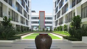 A modern building with a central courtyard featuring a large vase and a water feature. - PODZzz Suites at Aeropod - K2-07-10A (Kota Kinabalu)