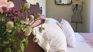 Ein Schlafzimmer mit einem Bett, einem Spiegel und einer Kommode.