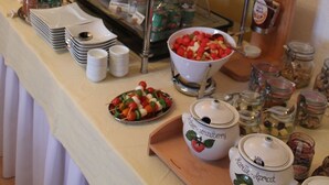 A buffet setup with various food items, including a tray of meats, a bowl of fruit, and several condiment dispensers. - Ferienwohnung im Erdgeschoss 45 qm, Schlafzimmer, Wohn-/Schlafraum, separate Küche, 4 Sterne, max. 4 Personen (Anger)