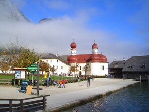 Ein Gebäude mit einer roten Kuppel und weißen Wänden, einer Anlegestelle und einem ruhigen Wasserabschnitt.