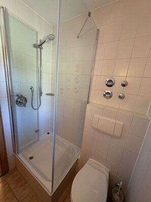 A bathroom with a glass-enclosed shower, a bathtub, a toilet, and a wall-mounted hand dryer. - Apartment no. 4 Amara for 1-3 pers., 42 m², 1 sep. bedroom. (Bischofswiesen)