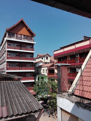 A multi-story building with balconies and a red roof. - Faa Apartment (Vientiane)
