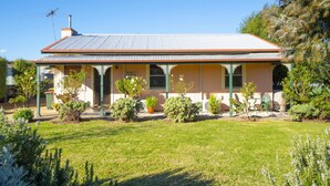A two-story house with a covered porch, a chimney, and a sign reading "Ruby's Cottage". - Rubys Cottage (Penola)
