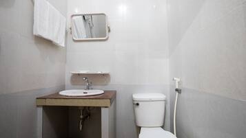 Une salle de bain avec des toilettes, un lavabo et un miroir.