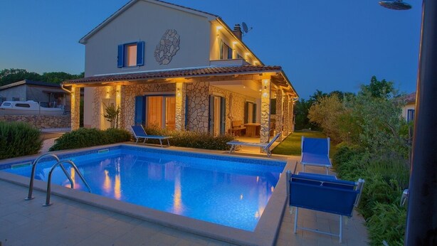 Ein zweistöckiges Haus mit Swimmingpool, Außenbereich und einer Steinfassade.