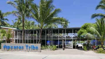 A modern building with a glass facade and a sign that reads "Hotel Tropical".