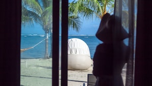 A beach view with a hammock, a large white bean bag, and a chair. - Apsaras Tribe - Siargao (General Luna)