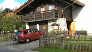 Ein zweigeschossiges Gebäude mit einem Holzbalkon und einem Steinunterbau.