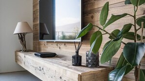 Un soggiorno moderno con una parete in legno, una TV a schermo piatto montata, una lampada e una pianta in vaso.