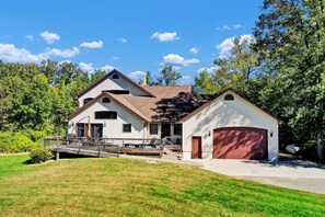 A two-story house with a garage, a covered patio, and a landscaped yard.