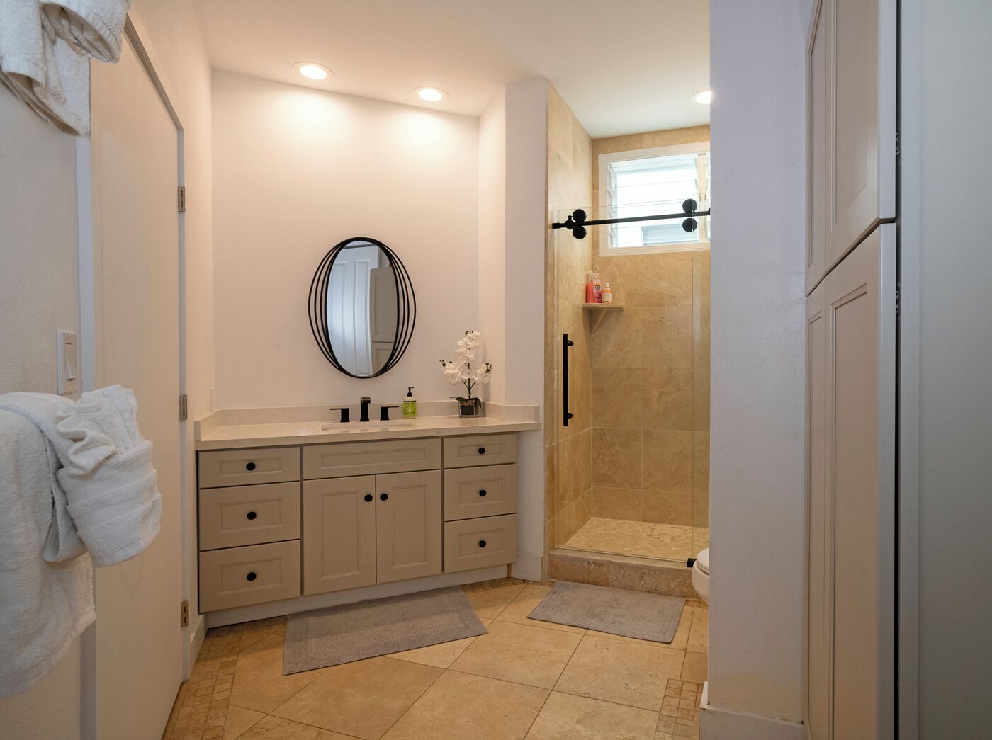 Une salle de bain moderne avec un meuble-lavabo, une douche et une douche à l’italienne.
