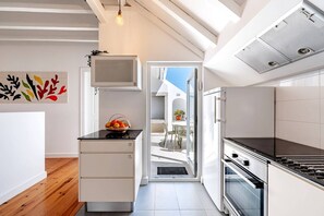 Una cocina moderna con horno integrado, refrigerador y comedor con mesa y sillas.