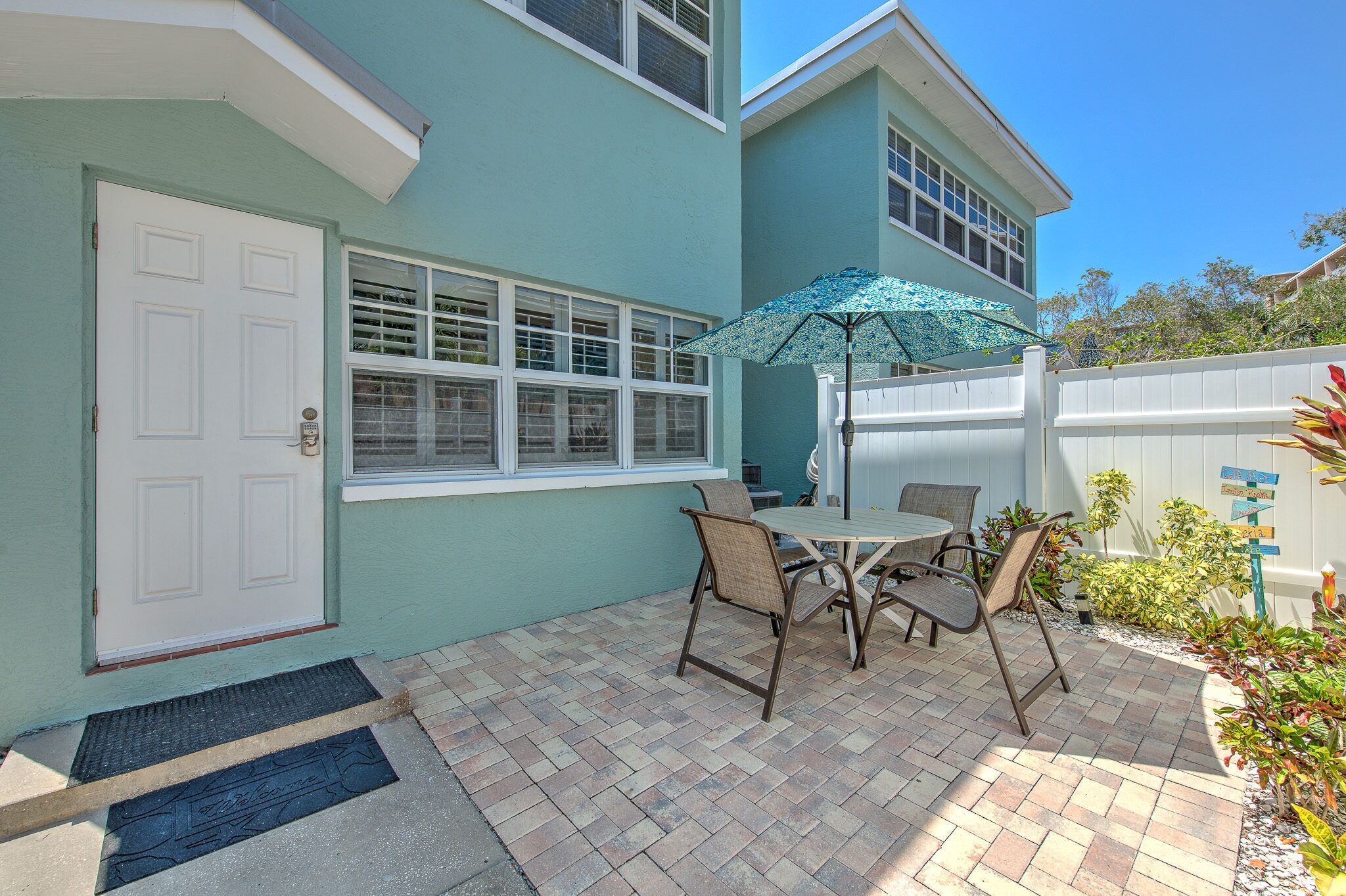A patio with a table and chairs, a door, and a window.